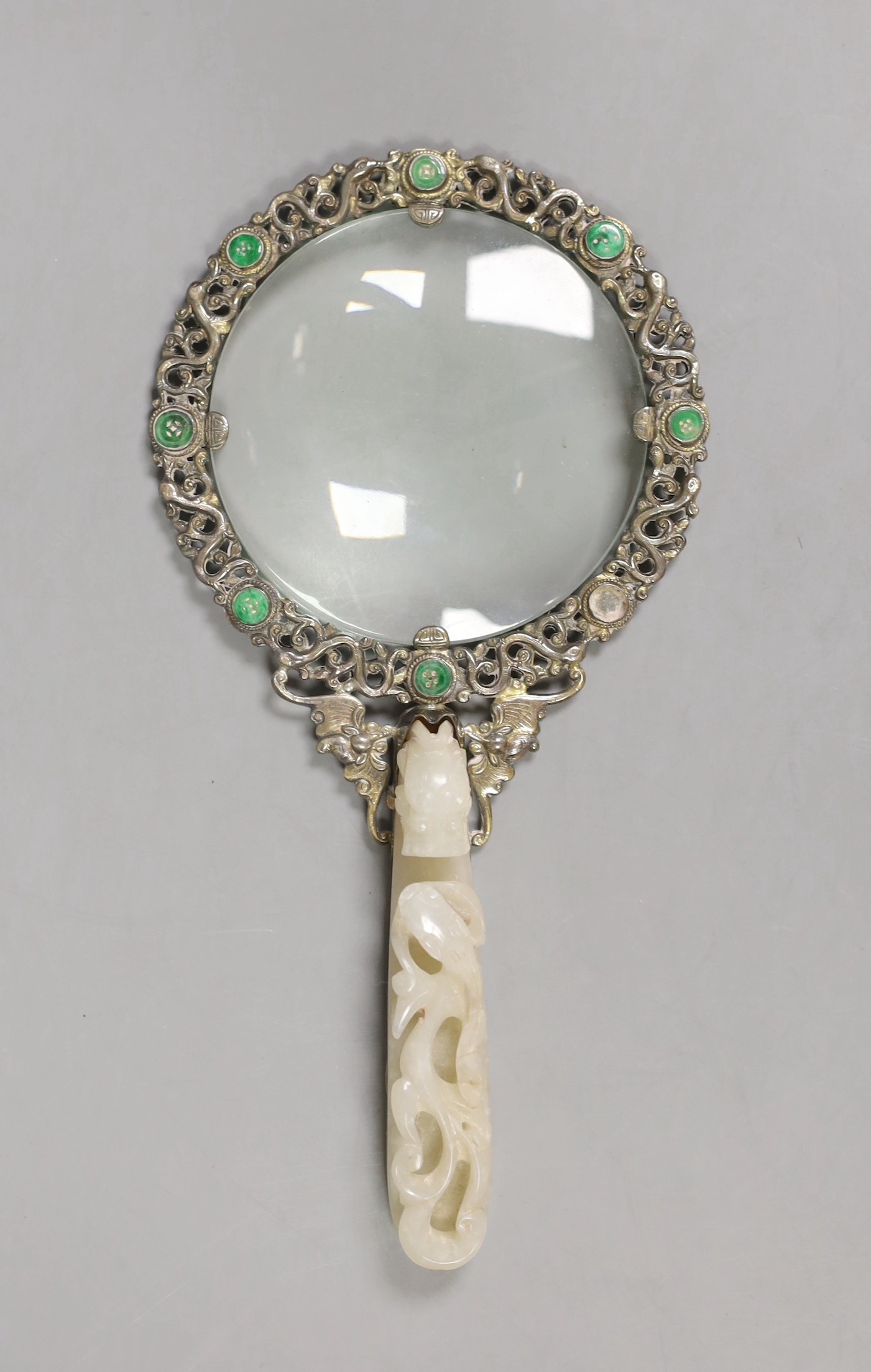 An Eastern white metal ‘SILVER’ marked magnifying glass with carved jade belt hook handle, total length 20cm